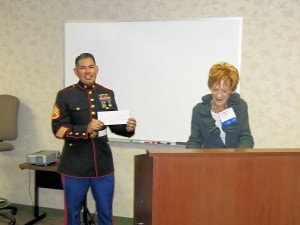 member of the Marine Corp being presented with a check for Toys for Tots