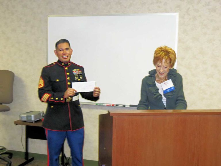 A member of the Marine Corp being presented with a check for Toys for Tots