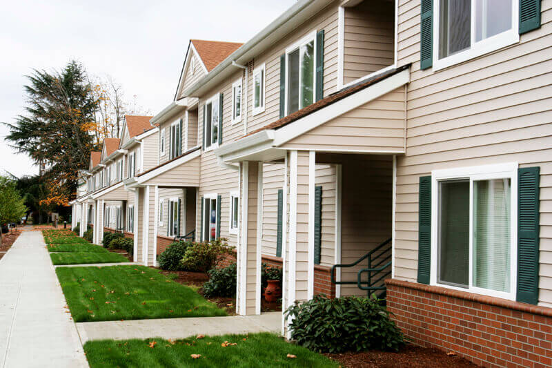 sidewalk view of a row of townhouse apartments