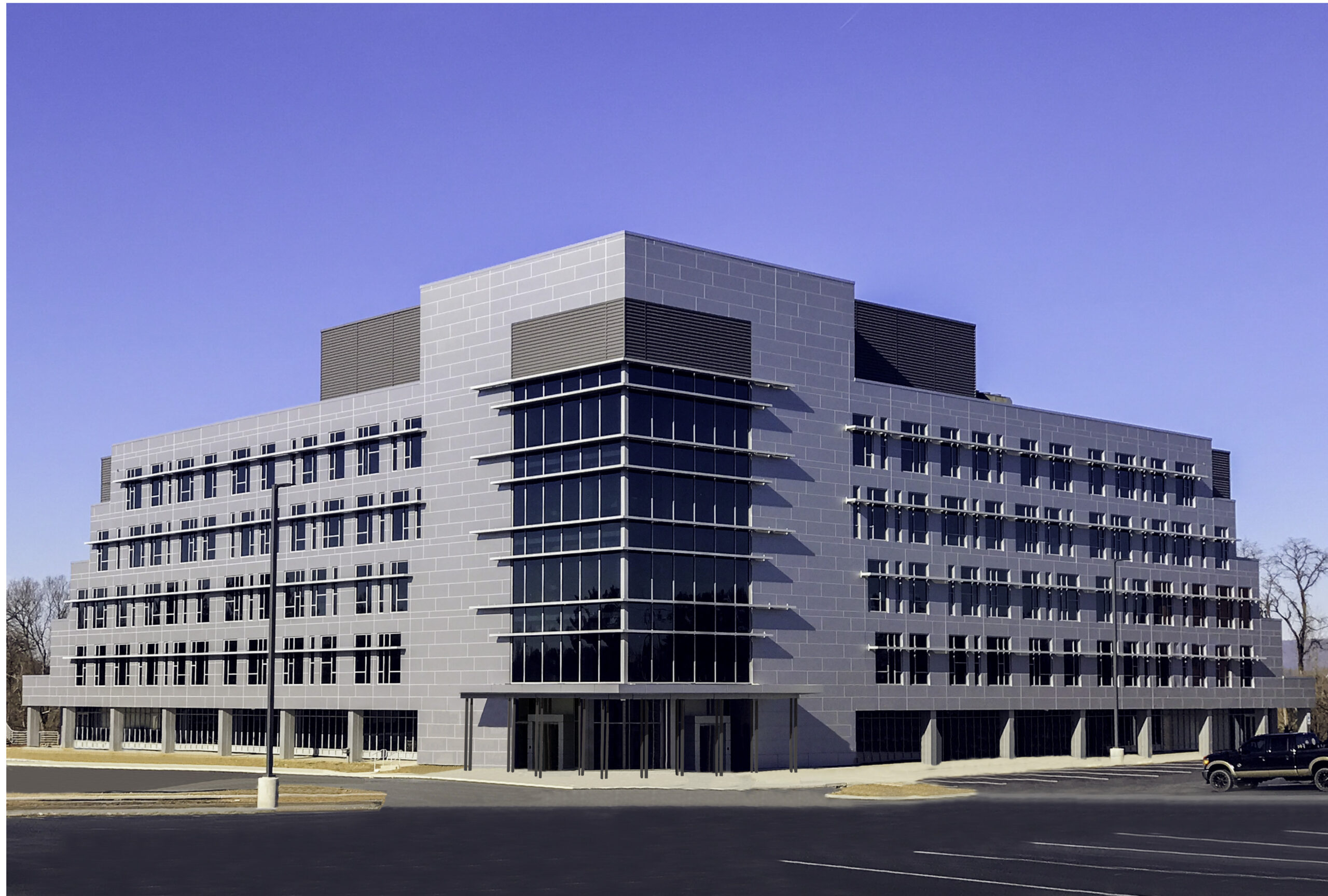 Modern commercial office building at 225 Grandview Avenue featuring sleek glass façade, clean architecture, and ample parking, showcased under a clear blue sky.