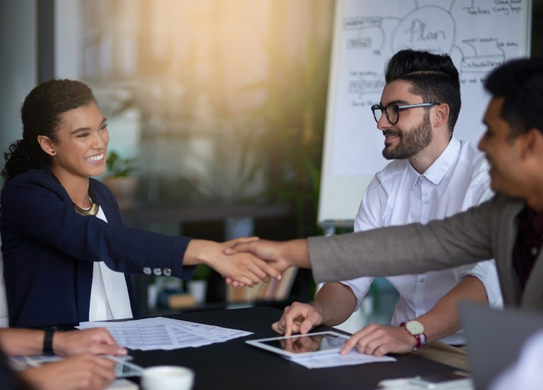 Two people shaking hands at a meeting