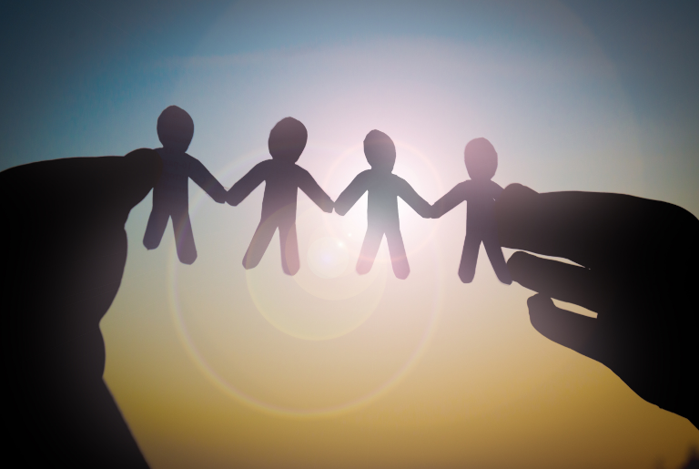 hand holding paper cutouts to sunlight